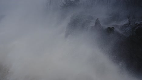 An-Einem-Düsteren,-Stürmischen-Tag-Stürzen-Raue-Ozeanwellen-Gegen-Eine-Felsige-Klippe,-Zeitlupe