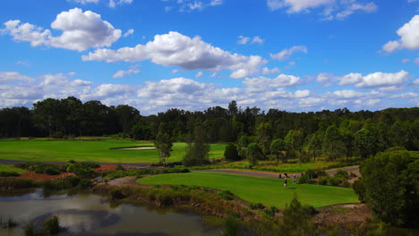 Golfistas-Masculinos-Jugando-En-La-Calle-Del-Campo-De-Golf-Bajo-Un-Hermoso-Cielo-Azul