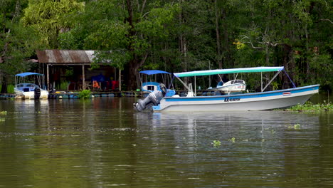 Hafenhafen-Im-Dschungelfluss-Von-Costa-Rica-Mit-Holzboot,-Das-Im-Wasser-Festgemacht-Ist-Und-Auf-Eine-Geführte-Touristentour-Wartet