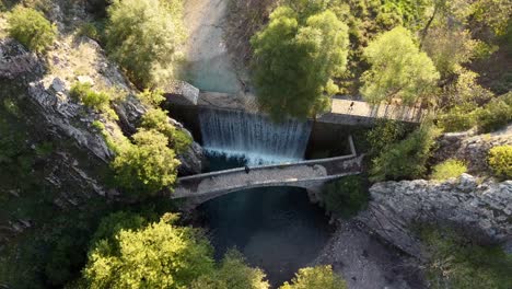 Cinematic-drone-4K-waterfall,-bridge-arch-surrounded-nature