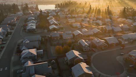 Aerial-view-of-a-suburban-neighborhood-with-roofs-covered-in-frost-during-the-sunrise