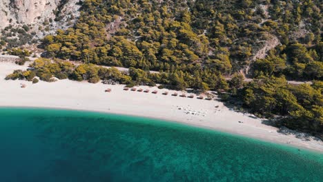 Una-Playa-Paradisíaca-Con-Resort-Al-Lado-De-Una-Montaña-Y-Mar-De-Aguas-Azules---Turquía
