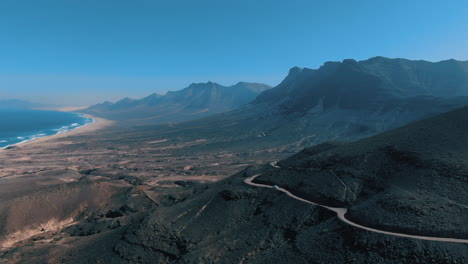 Wunderbare-Luftaufnahme-In-Großer-Höhe-über-Dem-Cofete-Naturpark-Auf-Der-Insel-Fuerteventura-Und-Wo-Man-Den-Fantastischen-Strand-Und-Die-Straßen-Der-Wunderschönen-Berge-In-Der-Umgebung-Sehen-Kann