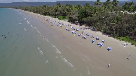 Beach-Chairs-And-Umbrellas-In-Four-Mile-Beach,-Port-Douglas,-Queensland,-Australia---aerial-drone-shot