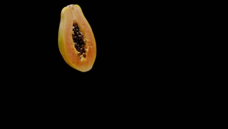 Delicious-papaya-fruit-isolated-on-black-background-falling,-super-slow-motion