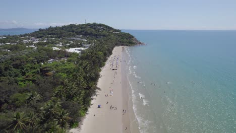 Tourists-Enjoying-Scenic-Four-Mile-Beach-In-Port-Douglas,-Queensland,-Australia---aerial-pullback