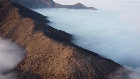 Circuling-drone-shot-of-the-mountains-of-Lima-Peru-above-the-clouds