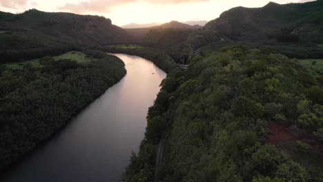 Dramatic-aerial-footage-of-famous-Wailua-River-during-sunset-with-a-driveway-in-the-background,-sunrise
