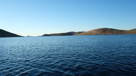 A-picturesque-landscape-of-calm-ocean-with-mountain-horizon-and-blue-sky-near-Kornati-National-Park-in-Croatia