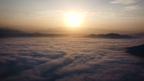 Horizon-view-of-a-drone-above-the-clouds-of-the-misty-mountains-and-a-sunrise-in-Lima-Peru