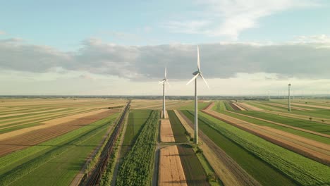 Aerial-follow-footage-of-wind-turbines-on-a-field-