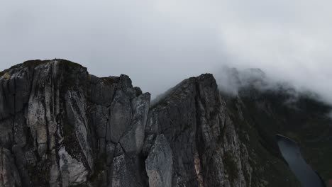 Fliegen-Entlang-Eines-Bergrückens-In-Norwegen,-Links-Keine-Sicht-Durch-Nebel-Und-Rechts-Ein-See-Im-Tal,-In-Slowmotion