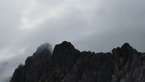 Fliegen-Entlang-Eines-Bergrückens-In-Norwegen,-Rechts-Keine-Sicht-Durch-Nebel-Und-Links-Der-Blick-Auf-Das-Meer-Im-Hintergrund,-Am-Ende-In-Den-Nebel-Fliegen