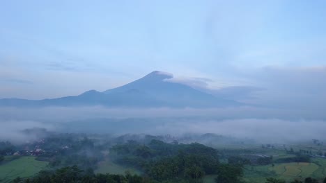 Aerial-panorama-view-of-foggy-green-landscape-with-Volcano-in-background-in-the-morning---Mount-Sumbing-in-Indonesia