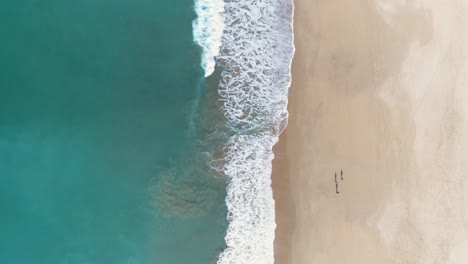 Luftaufnahme-Von-Türkisblauen-Meereswellen,-Die-Auf-Dem-Sand-Eines-Wunderschönen-Weißen-Sandstrandes-Brechen