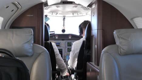 Back-View-Of-Pilot-And-Co-Pilot-In-The-Cockpit-Of-A-Private-Jet-Plane