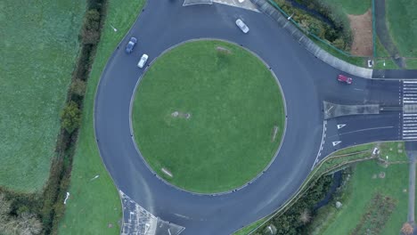 Vehicles-drive-on-green-Irish-highway-roundabout-near-verdant-pastures