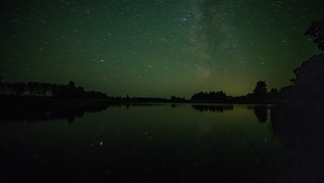 Dramatic-time-lapse-of-starry-milky-way-night-sky-changing-colors-and-reflection-on-water