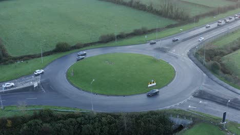 Aerial-view-of-vehicle-traffic-on-green-highway-roundabout-in-Ireland