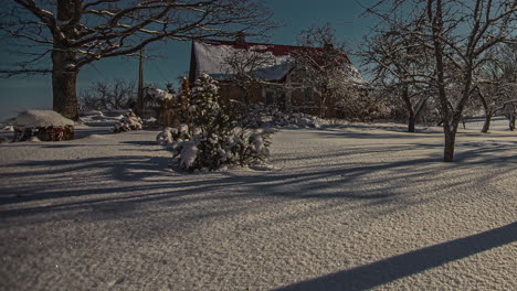 Beautiful-timeline-of-sunlight-shadow-moving-through-fresh-snow-covered-empty-front-yard-of-wooden-holiday-house,-low-and-wide-angle-shot