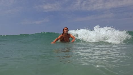 Seawater-surface-point-of-view-of-adult-active-woman-having-fun-on-summer-holidays-waiting-big-sea-wave-breaking-on-her