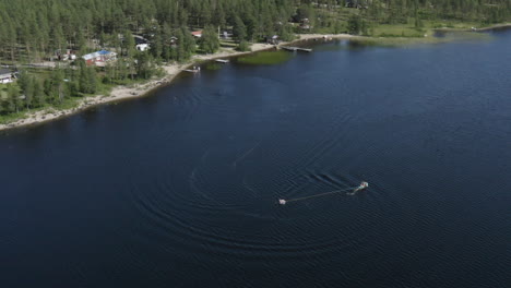 Top-view-drone-shot-of-young-people-riding-a-jetski-in-a-river-in-Sweden