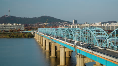 Tráfico-De-Automóviles-Del-Puente-Dongjak-Y-Movimiento-Del-Tren-Subterráneo-Durante-El-Día-Con-Vista-De-Lapso-De-Tiempo-De-La-Torre-N-Seoul-Namsan