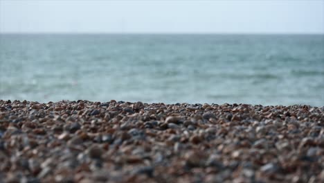 tilt-up:-pebbles-on-a-brighton-beach,-sussex,-united-kingdom,-english-channel-on-the-horizon