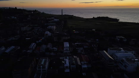 Rising-drone-Shot-looking-out-to-sea-over-houses-with-dusky-sky