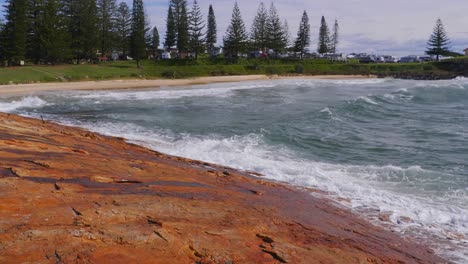 Atemberaubender-Strand-In-South-West-Rocks,-Australien---Reflexion-Des-Sonnenlichts-Auf-Dem-Welligen-Meer---Schwenkaufnahme