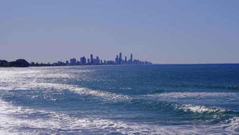 Blue-Waves-At-Burleigh-Heads-Beach---Gold-Coast-Skyline-In-The-Distance---Queensland,-Australia