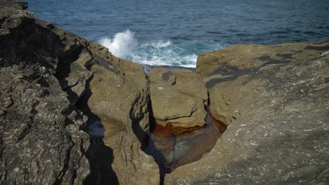 Rocas-Costeras-Con-Olas-Oceánicas-En-El-Fondo---Suburbios-Del-Este-En-Sydney,-Nueva-Gales-Del-Sur,-Australia