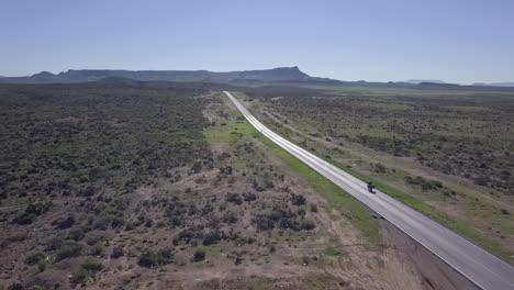 Lone-Wolf-Biker-Driving-on-Highway-Through-Baja-California-Desert,-Mexico,-Aerial-Tracking