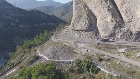 Reveal-Car-Driving-Through-the-Mountain-Tunnel-on-Curved-Road,-Aerial
