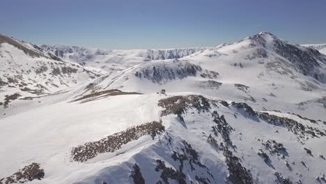 Skiers-on-Top-of-Snow-Convered-Mountain-Peak-in-Dakota,-US,-Aerial