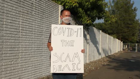 Anti-COVID-Protester-with-Mesh-Mask---Scam-Demic-Tracking-Shot