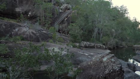 Agua-Que-Fluye-En-El-Río-Rocoso-En-El-Bosque---Casa-De-Vacaciones-Situada-Al-Borde-De-Un-Acantilado-Rocoso-En-Mount-Byron,-Queensland,-Australia