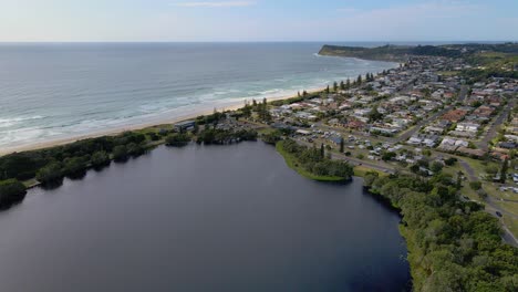 Lake-Ainsworth-Surrounded-By-Tea-Trees-At-The-Ocean-Coast---Lennox-Head,-NSW,-Australia---aerial-drone