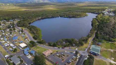 Beautiful-Lake-Ainsworth---Tea-Tree-Stained-Dunal-Lake-In-Lennox-Head---NSW,-Australia---pullback-drone-shot