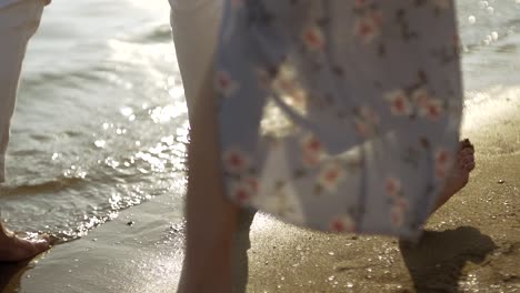 Feet-of-couple-walking-barefoot-on-beach