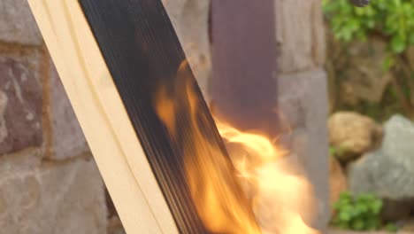 Pine-wood-plank-surface-being-burned-with-blowtorch,-closeup