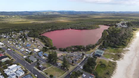 Discolored-Water-Of-Lake-Ainsworth-In-Lennox-Head---Wonderful-Spot-In-NSW,-Australia---pullback-drone-shot