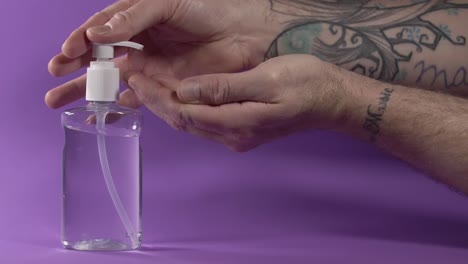 Hand-Sterilization-using-alcoholic-based-sanitizer-gel-on-purple-background