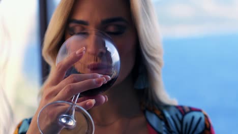 model-woman-drinking-red-wine-while-looking-at-camera