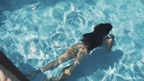 young-girl-swims-from-the-bottom-in-the-pool