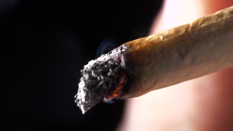 Closeup-on-rolled-cigarette-lit-with-burning-flame-inhaled---smoking-recreational-pursuit