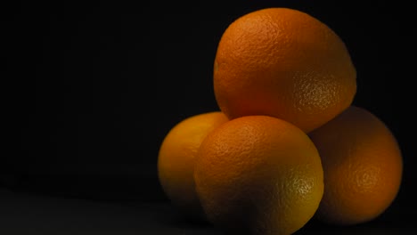 Statische-Aufnahme-Von-Orangenfrüchten,-Schwarzer-Hintergrund,-Textplatzhalter