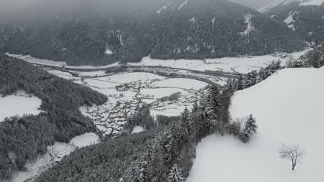 dark-moody-snow-storm-in-the-italian-alps,-you-can-see-a-cold-valley-and-village