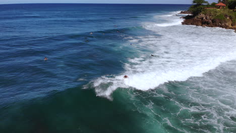 Surfer-rides-a-wave-crashing-in-the-ocean-in-Rincon-Puerto-Rico-during-a-clear-day-with-blue-sky