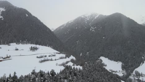 Tormenta-De-Nieve-De-Mal-Humor-Oscuro-En-Los-Alpes-Italianos,-Puedes-Ver-Un-Valle-Frío-Y-Un-Pueblo